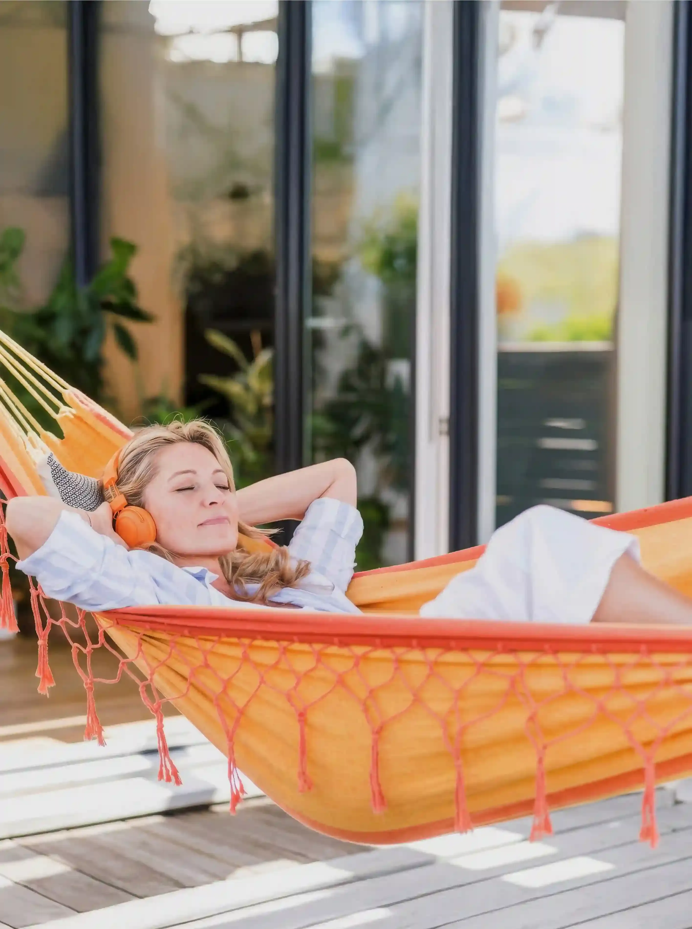 Woman relaxing in a hammock wearing headphones